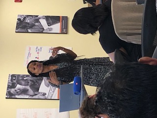 woman standing and speaking at front of room