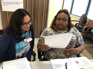 two women at a table looking over a piece of paper