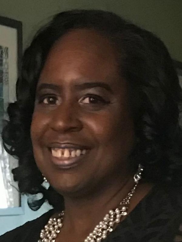 Headshot of Black woman wearing pearls