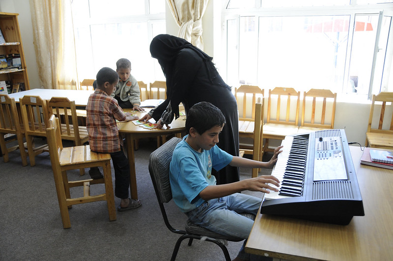 image of woman in classroom with students playing instrumetns