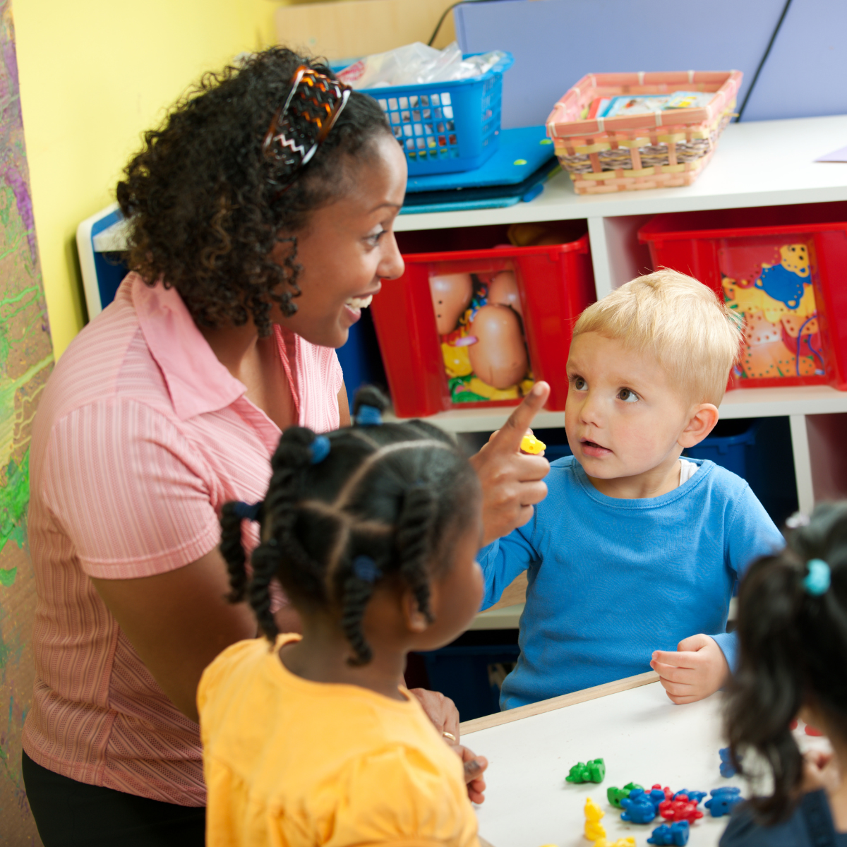 Woman teacher at a table with preschool students