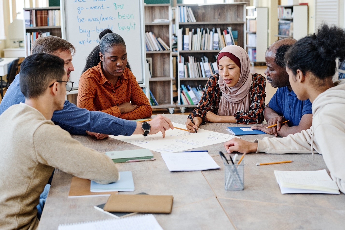 A diverse group of students sitting together in a library to study