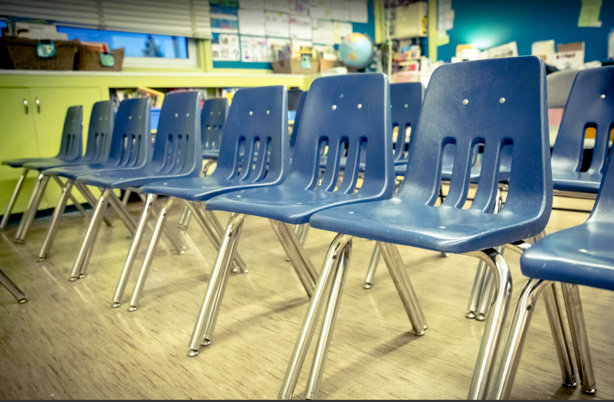 Blue plastic chairs lined up in a classroom 