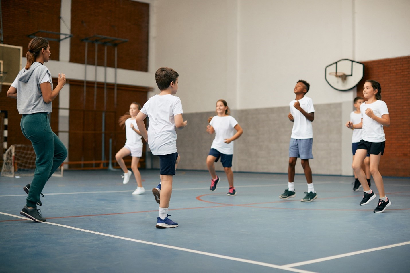 Group of elementary students running in place in gym class