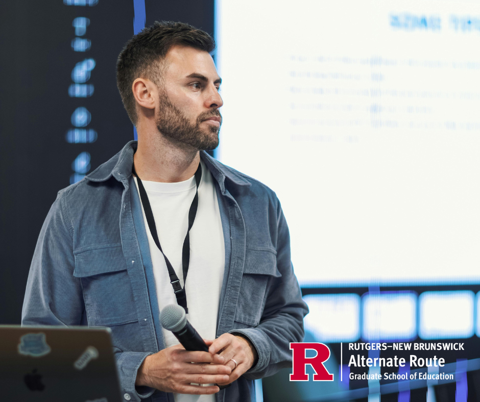 Conference speaker standing onstage, holding a microphone and looking at the audience