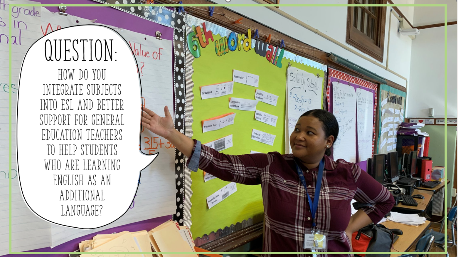 Woman standing at the front of the classroom, pointing to a board