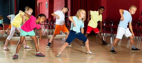 Group of elementary students dancing in a gym
