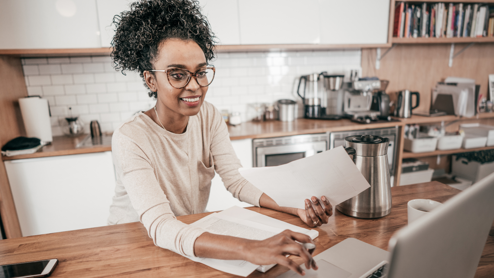 Black woman in front of computer at her kitchen table