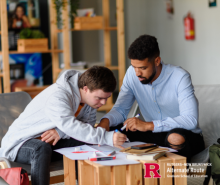A special education teacher working on an assignment with a student