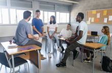 Teachers and students gathered in a classroom after school to collaborate and strategize