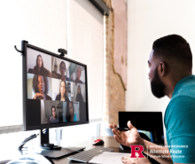 Man in front of a desktop computer, on a virtual meeting with other people