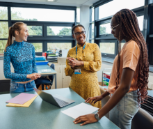 Diverse group of female teachers standing around a desk