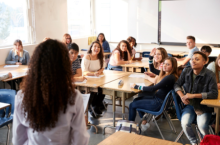 Teacher in front of a classroom of high school students at their desks