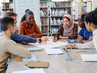 A diverse group of students sitting together in a library to study