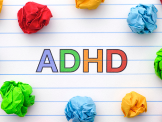 Lined notebook paper with colorful pieces of crumpled up paper and the acronym ADHD