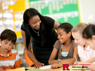 Teacher standing at table with students, explaining how to play a game