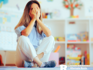 Female teacher sitting down, stressed, with her hands on her face