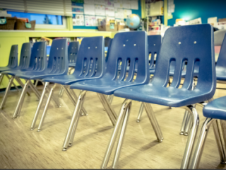 Blue plastic chairs lined up in a classroom 