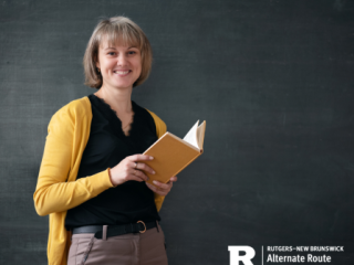 Woman holding a book in front of a chalkboard