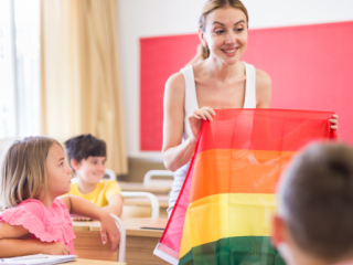 Teacher holding a Pride flag