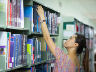 Young woman browsing library shelves