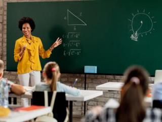 Woman standing in front of a chalkboard with a math equation written on it