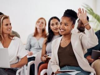 Woman raising her hand at a professional learning conference