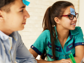 Adolescent-aged students playing a game with post-it notes on their foreheads