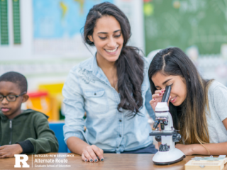 Teacher next to a student looking into a microscope