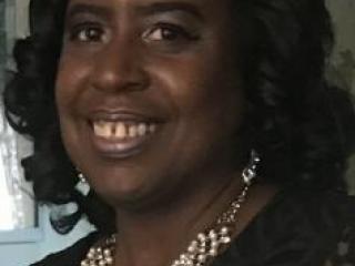 Headshot of Black woman wearing pearls