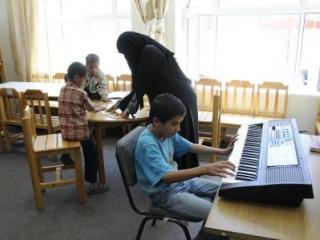 woman in classroom with students playing instruments