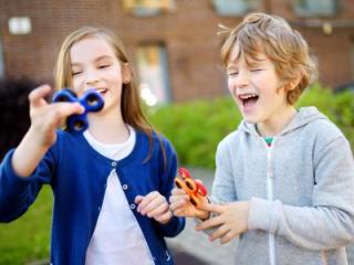 A boy and a girl playing with fidget spinners