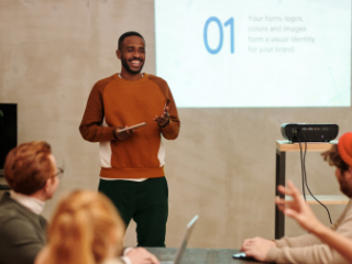 Black man presenting in front of diverse peers