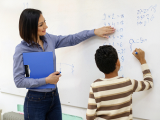 woman at whiteboard with young male student