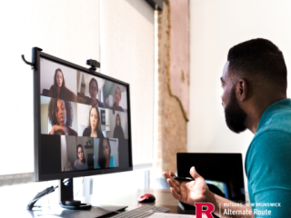 Man in front of a desktop computer, on a virtual meeting with other people