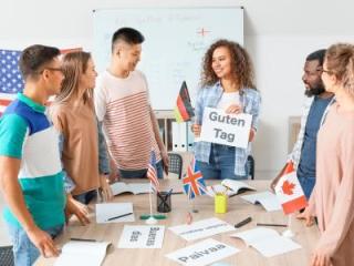 Group of students gathered around a table with language notecards and the flags for America, Germany, Great Britain and Canada