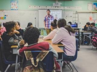 Male teacher in front of classroom