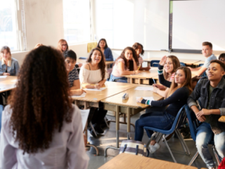 Teacher in front of a classroom of high school students at their desks